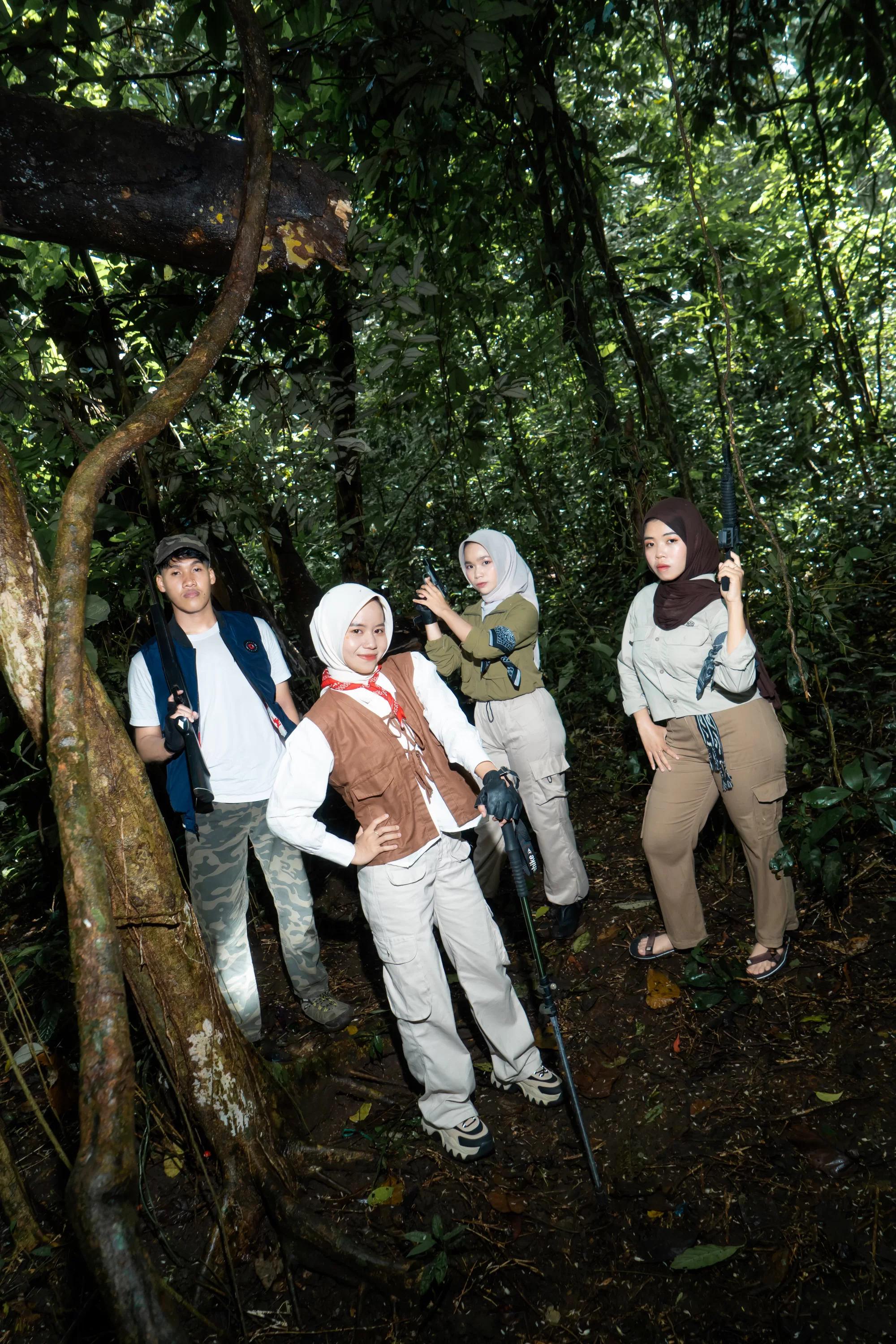 Sekelompok siswa berpose mengenakan pakaian sporty dan kasual bernuansa petualangan di jalur setapak tengah hutan yang lebat