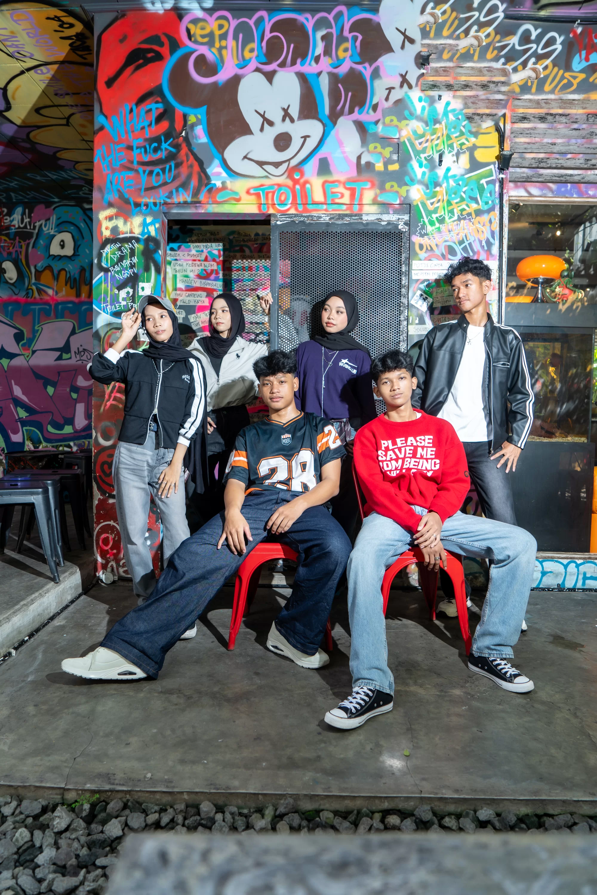 Pose kompak angkatan sekolah dengan balutan pakaian warna-warni cerah berlayer gaya streetwear Y2K
