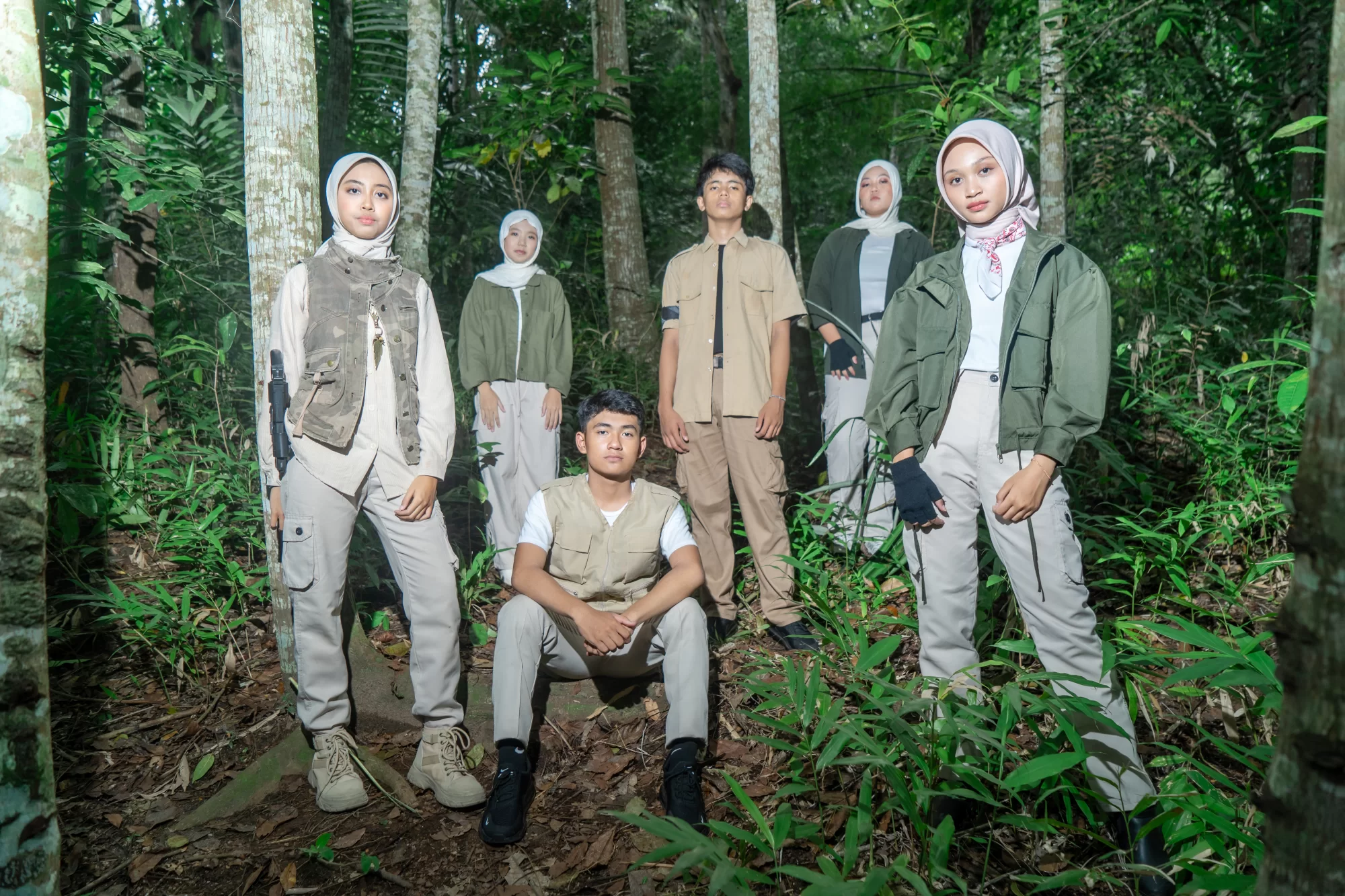 Pose lengkap angkatan berdiri tegak di tengah lebatnya pepohonan hutan liar dengan gaya penjelajah siap menghadapi tantangan Jumanji