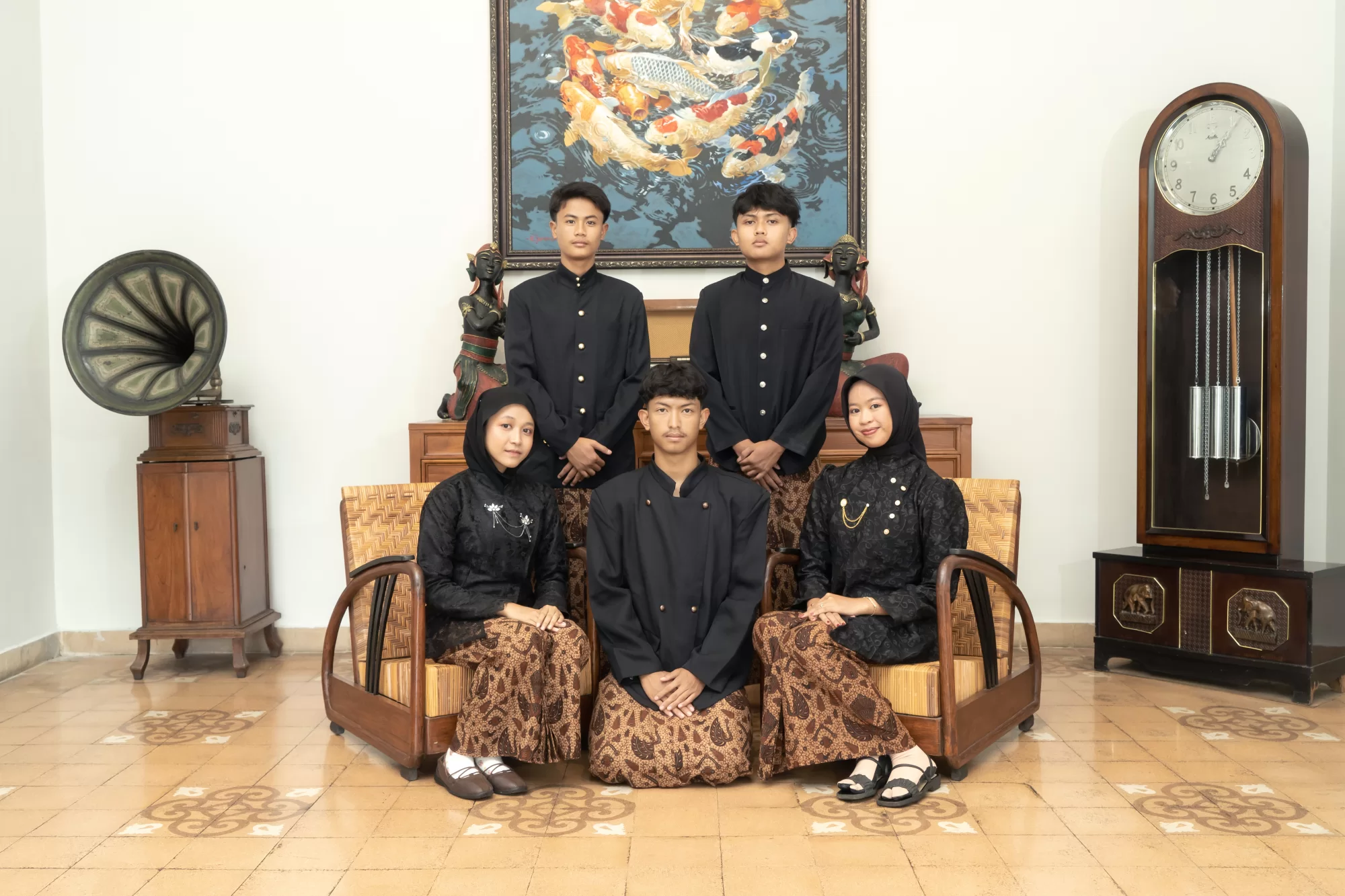 : Sekelompok siswa berpose dengan gaya busana vintage era kolonial di halaman bangunan arsitektur klasik
